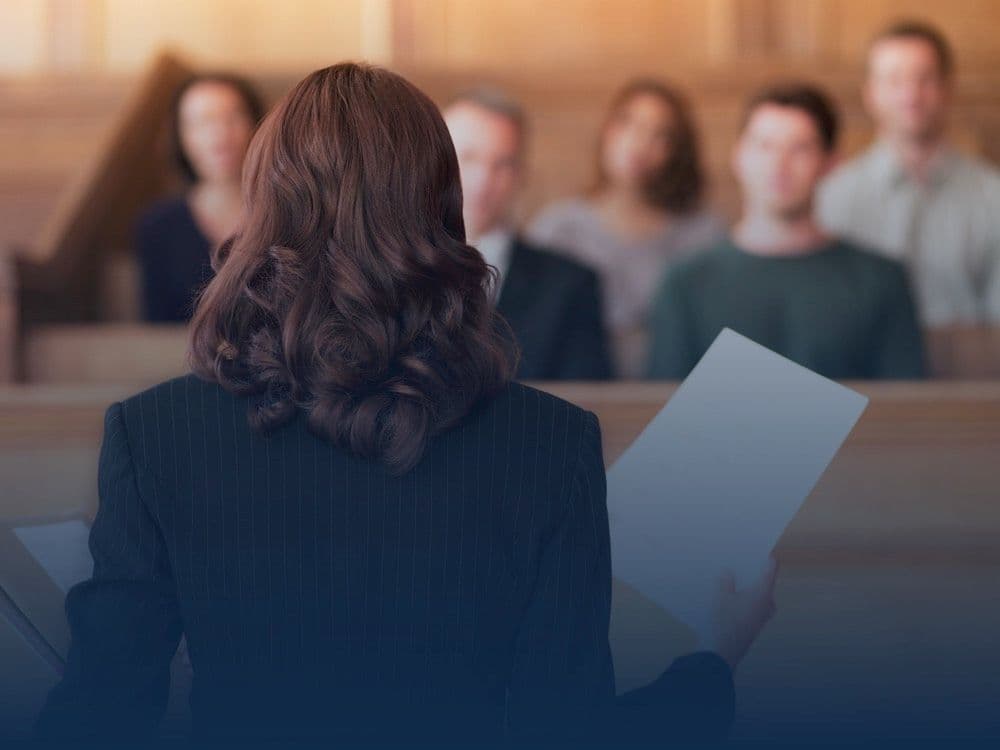 Attorney seen from behind holding papers while addressing a jury in a courtroom, overlaid with a blue geometric network graphic